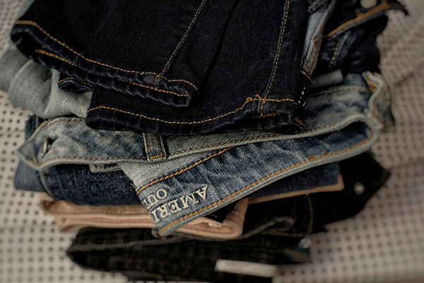 Pile of name brand jeans ready for consignment