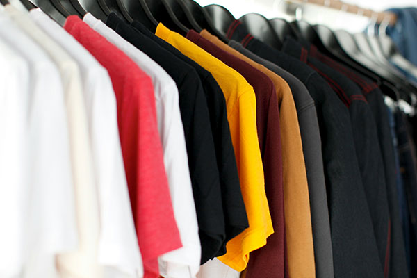 Colourful used clothing on hangers at a store